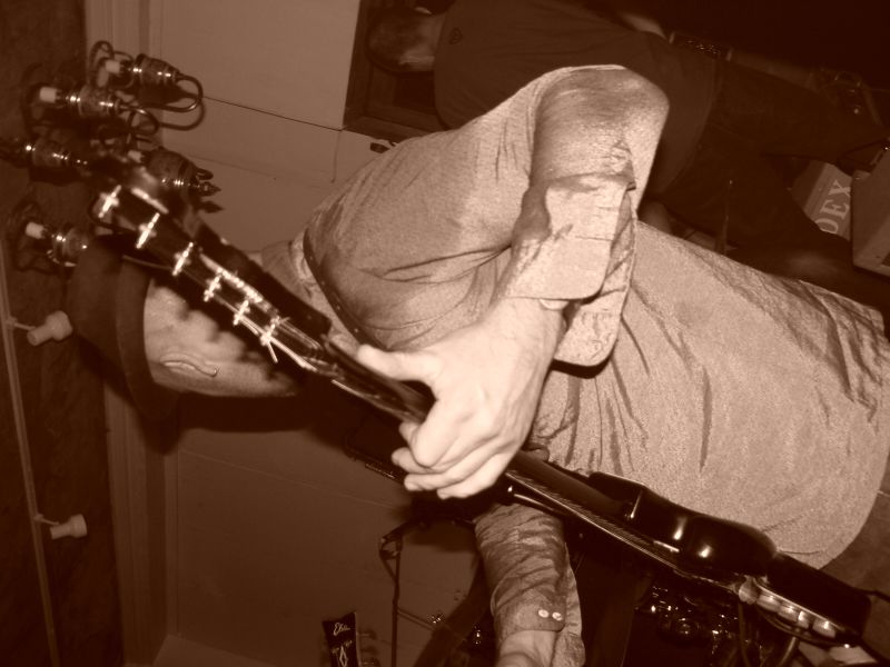 a man standing next to a bar while holding a guitar