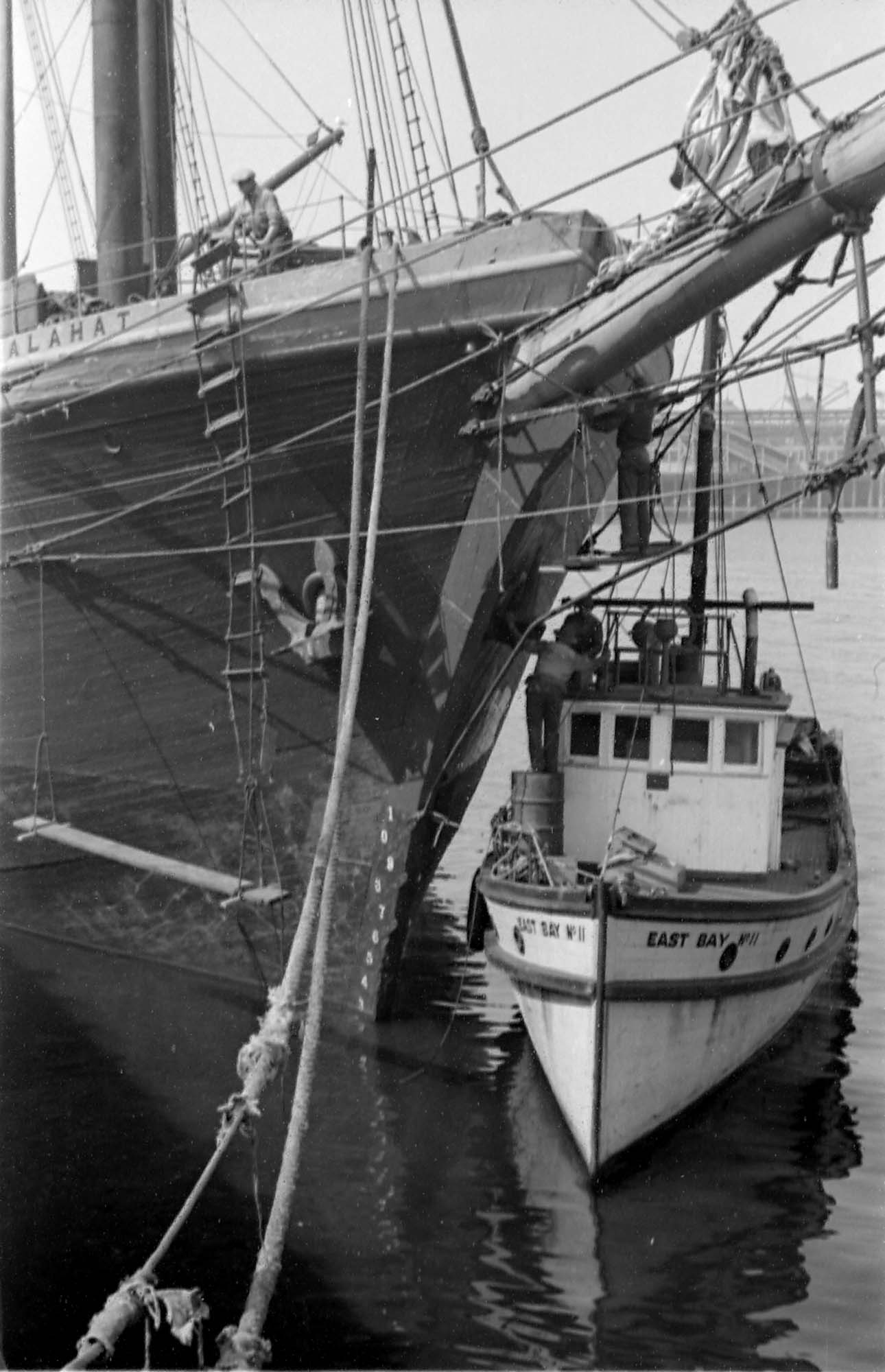 a large ship and smaller boat moored at a dock