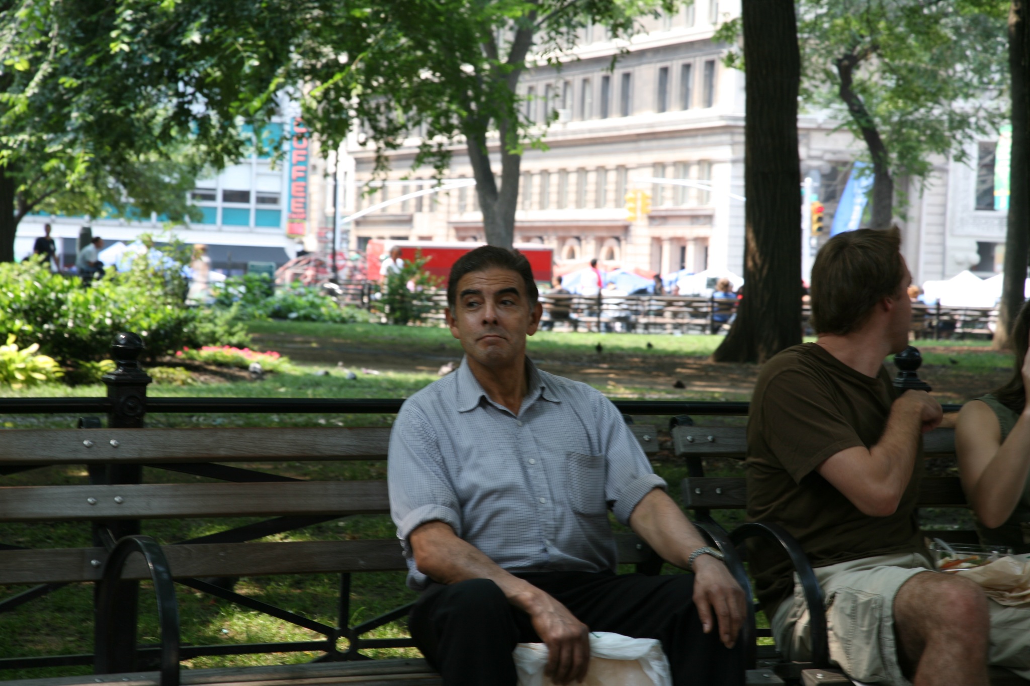 a man in shorts sits on a park bench
