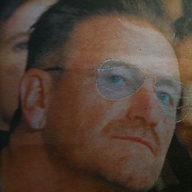 a man's glasses is reflected in his face