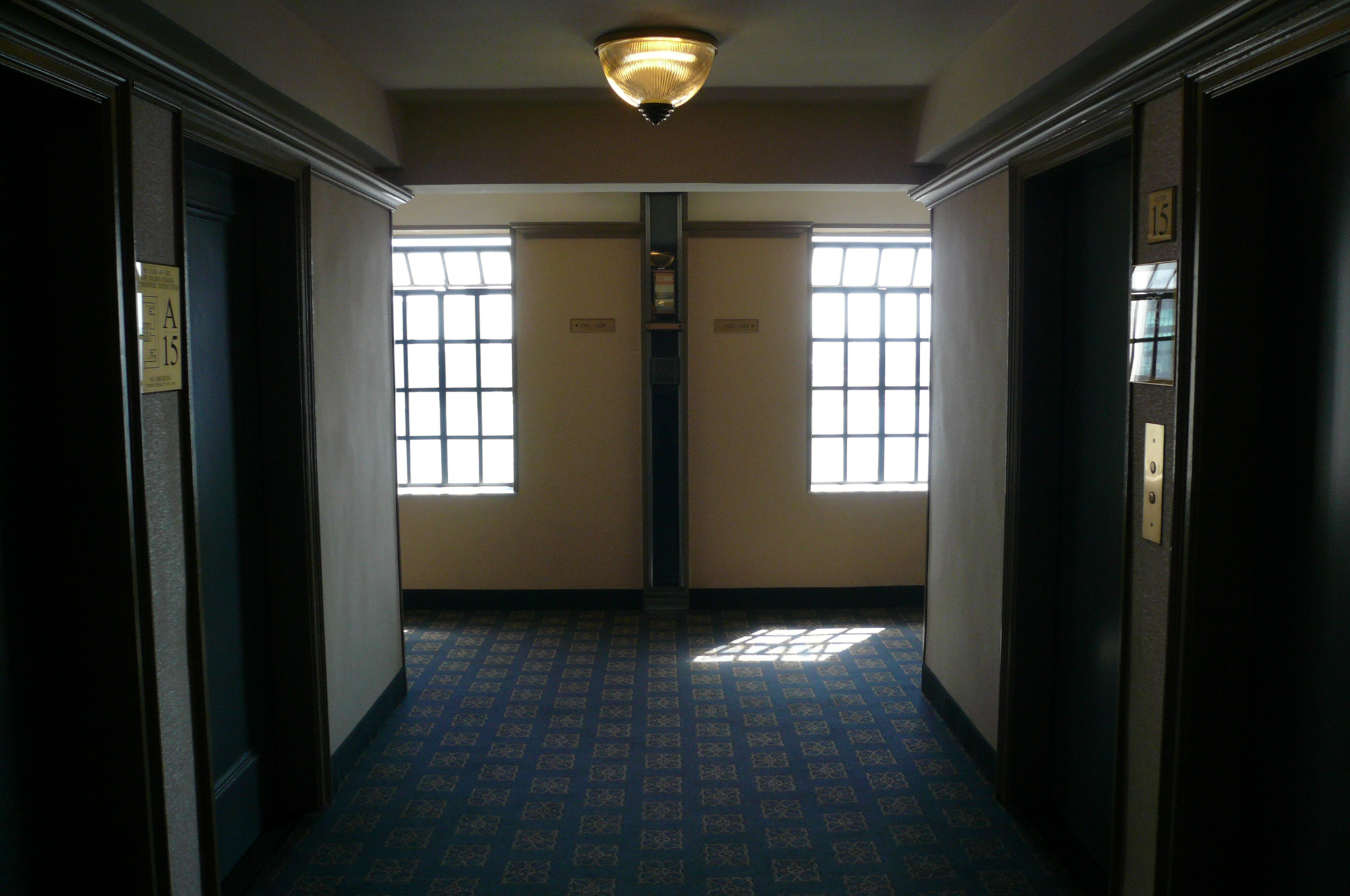 an empty corridor in a building with doors open