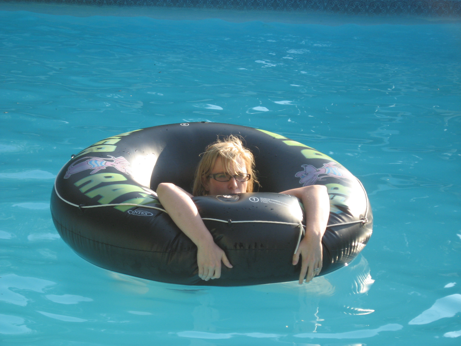 woman floating in a pool with a giant inflatable swimming ring