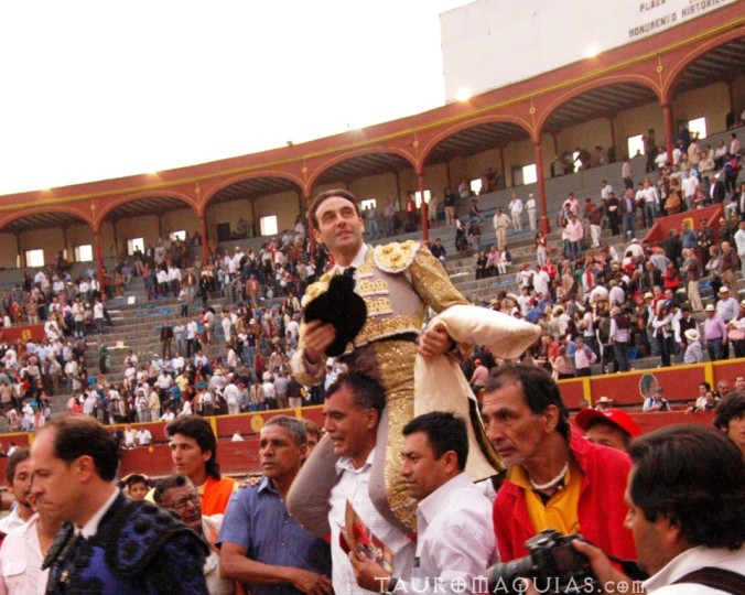 a man standing on top of a giant bull in a stadium