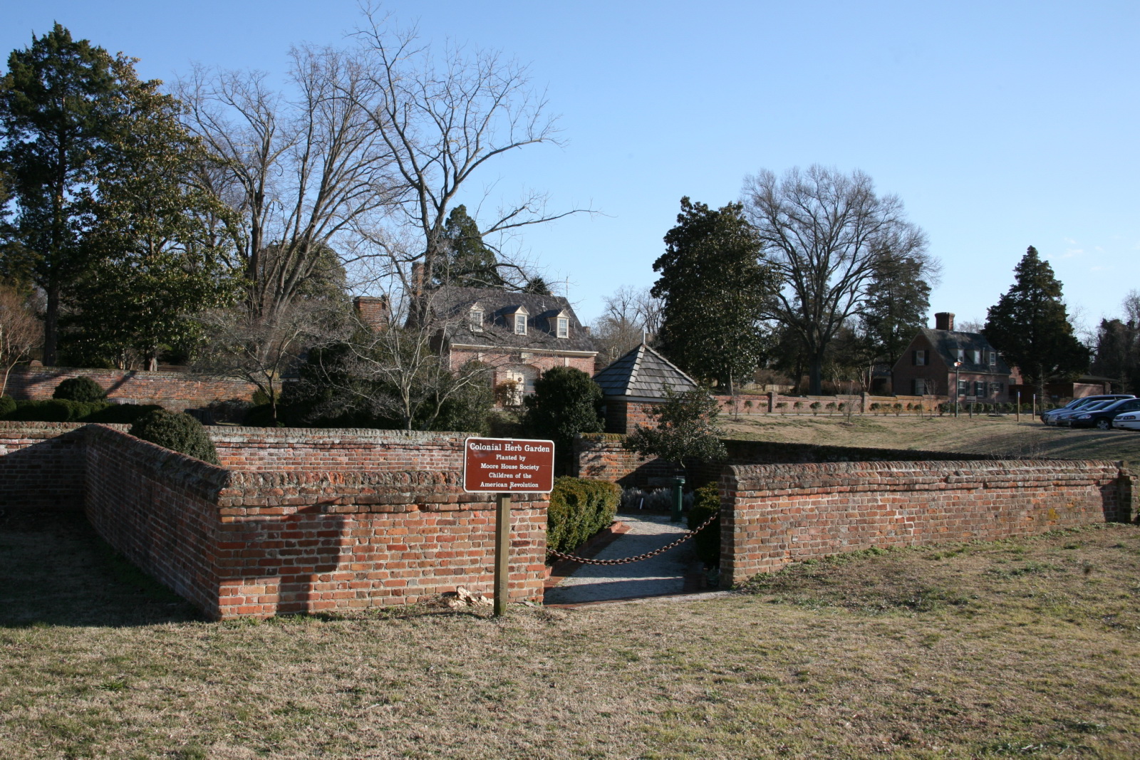 an open walled area with trees, cars and houses