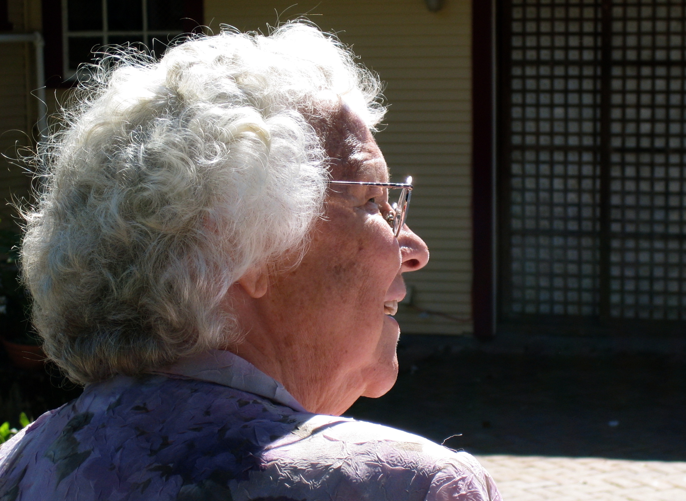 a woman wearing glasses looking off into the distance