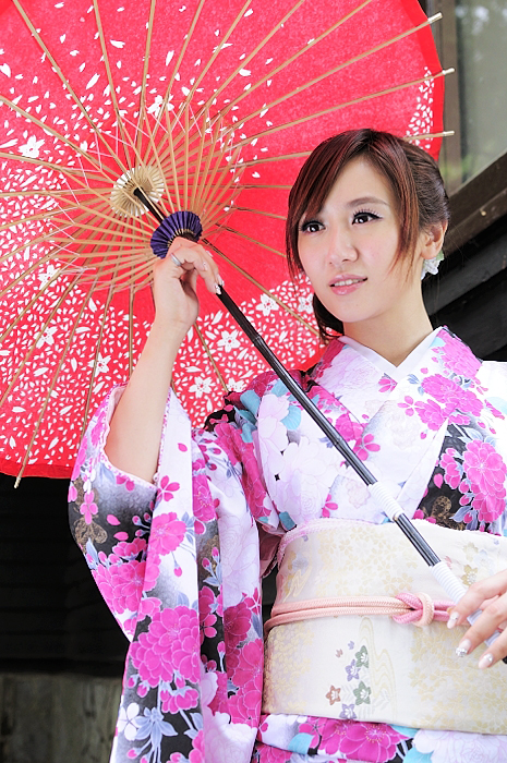 a beautiful young woman holding an oriental fan