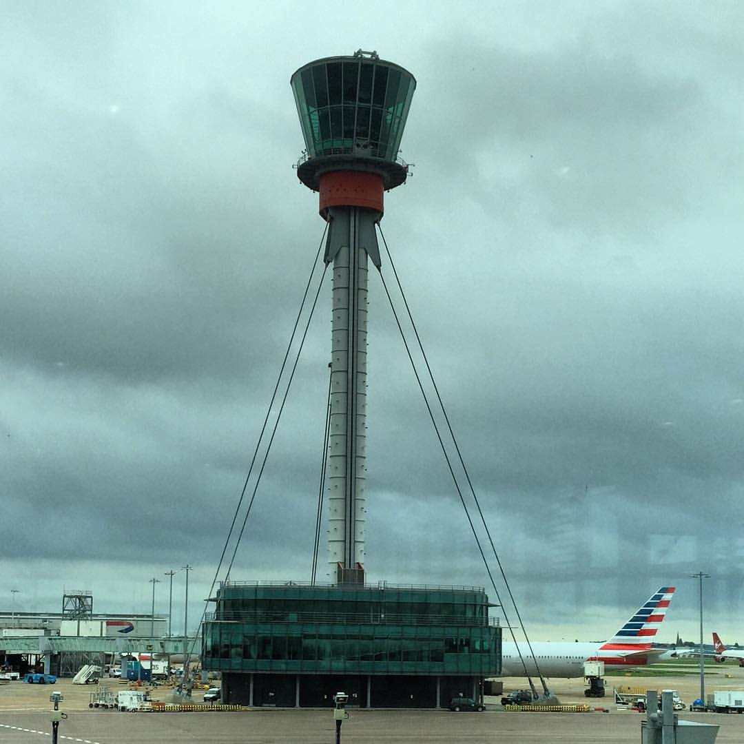 an airport with a passenger plane parked and people looking at the planes