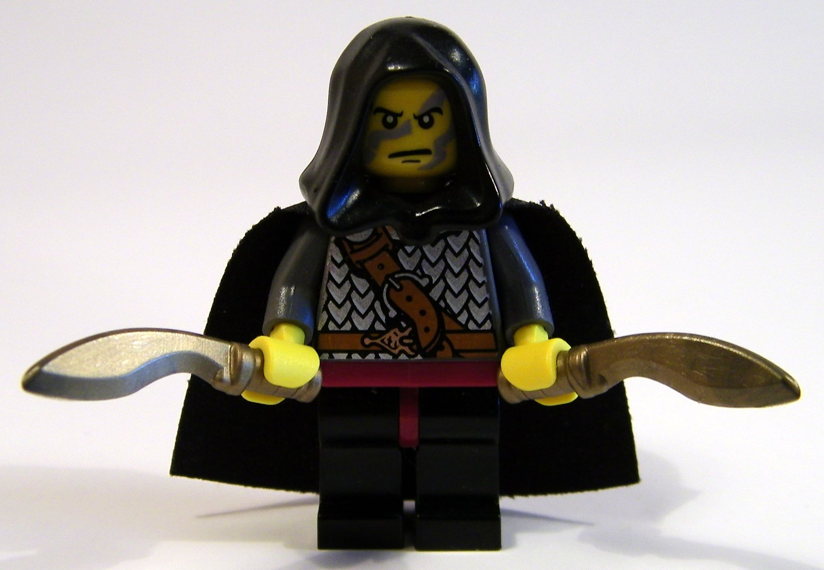 a lego figurine is holding a sword and an axe