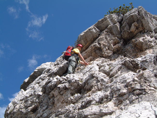 a person climbing up a large mountain on a sunny day