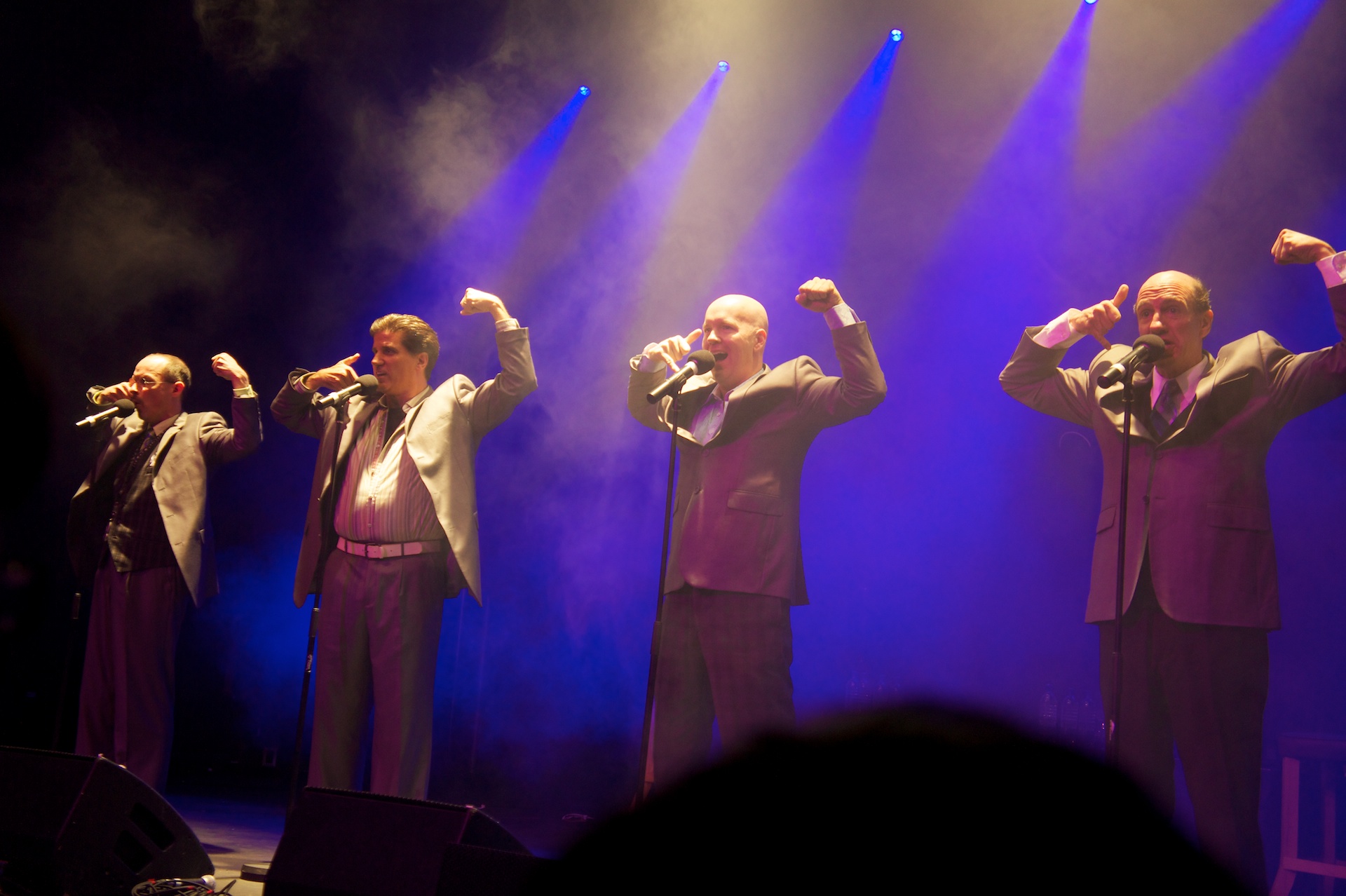 a group of people on stage with microphones in their hands