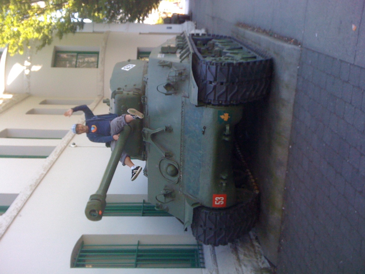 a boy rides atop the tank on display