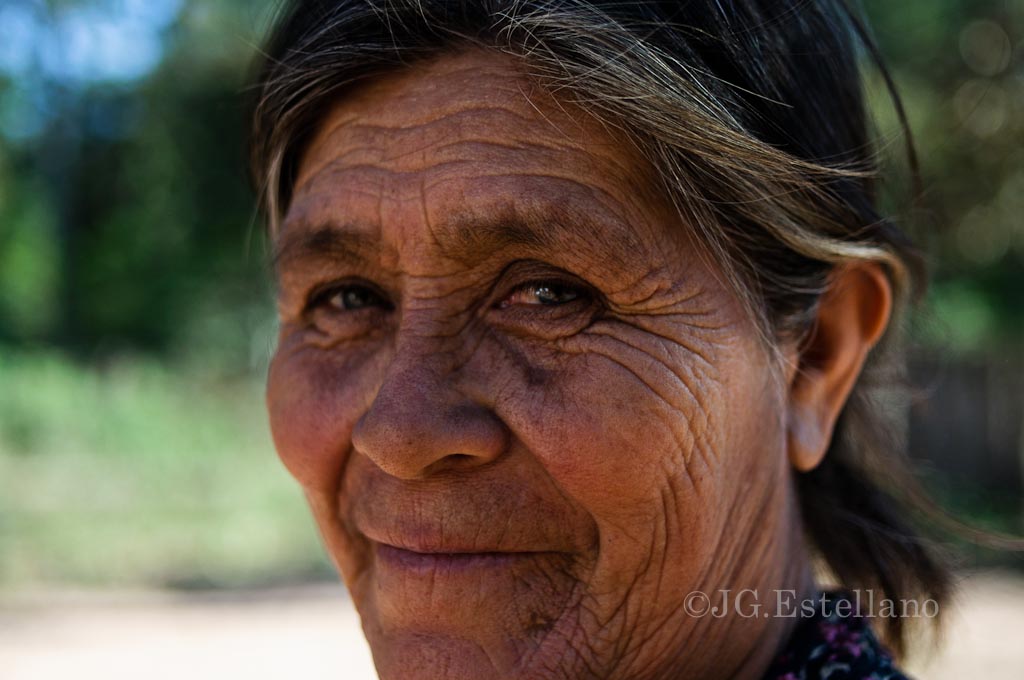 an old woman with wrinkles smiles into the camera