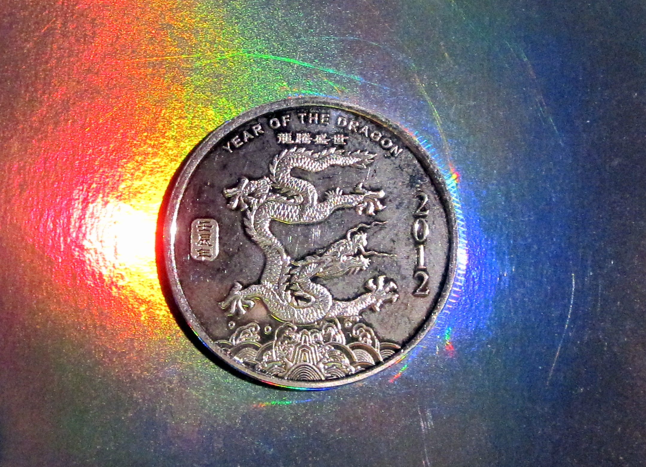 a coin with an dragon emblem is shown in front of a colorful background