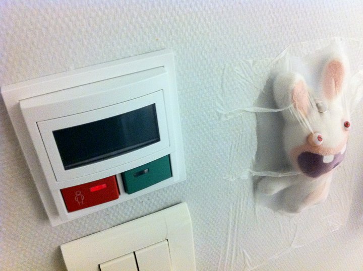 a rabbit - like clock on the wall next to a switch