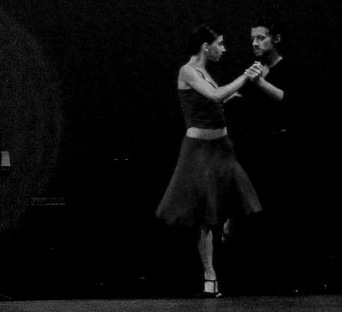 two people standing in the middle of a dance