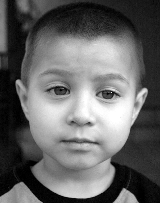 an infant boy with short hair looking down