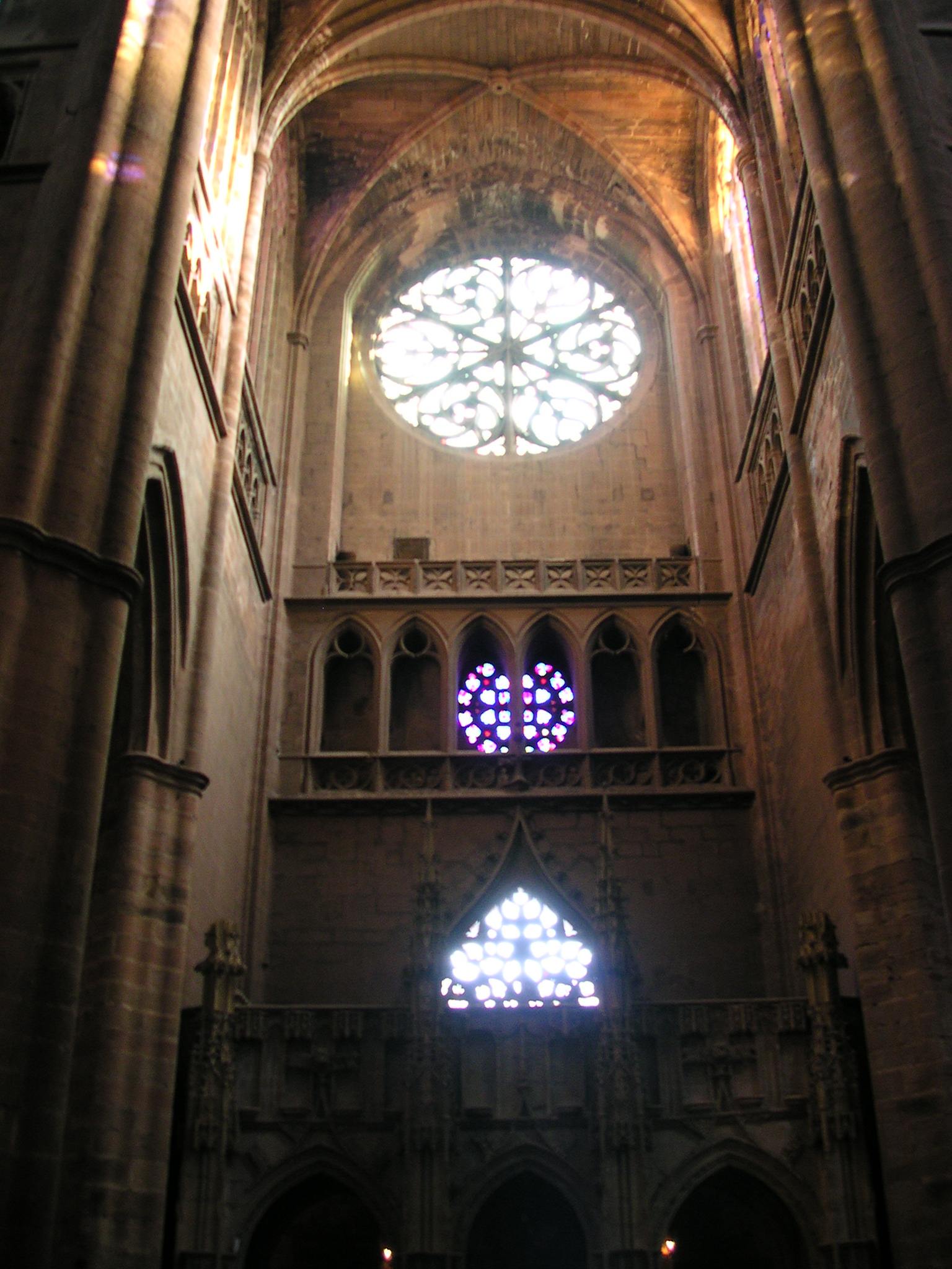 an ornate cathedral with a few bright stained glass windows