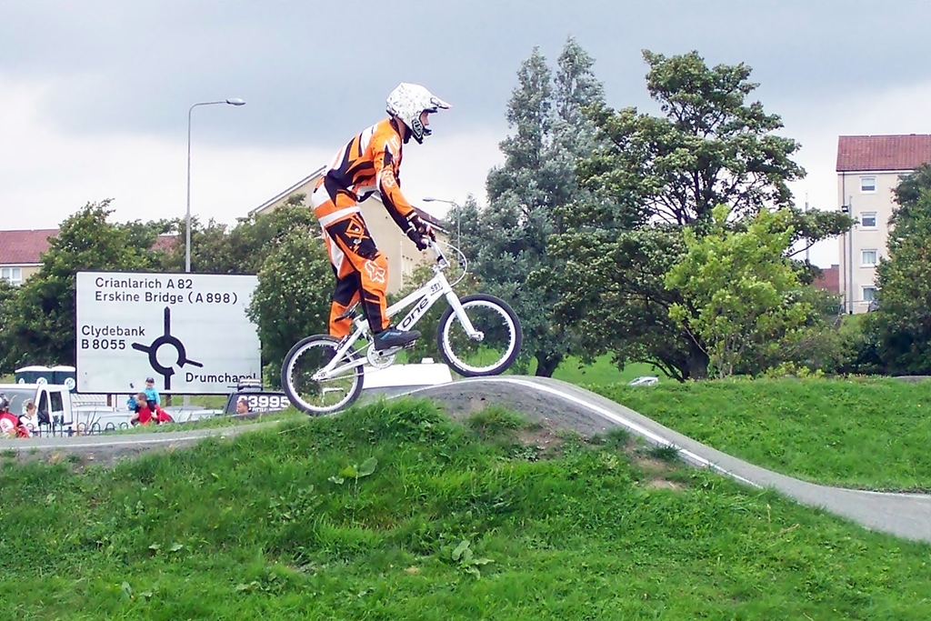 a man rides on a bicycle over a curve