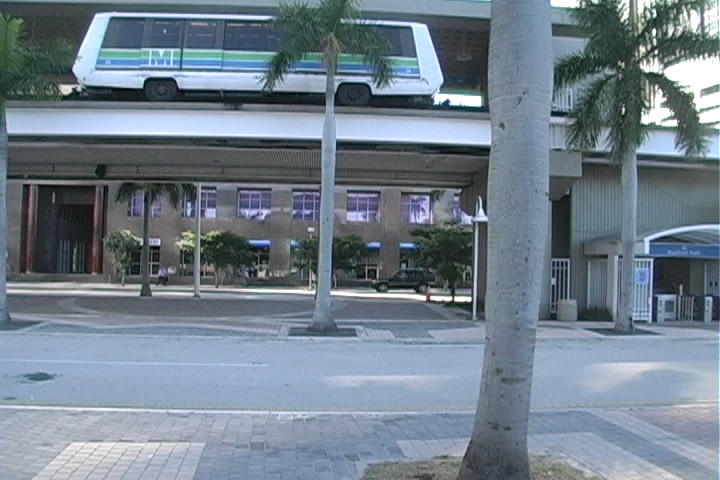 a bus sits on top of the building above palm trees