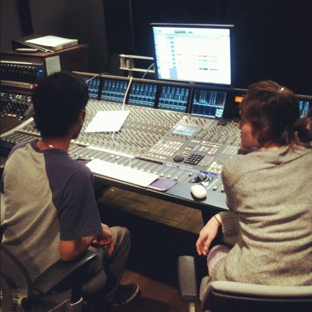 the woman and boy are working at the music mixing desk