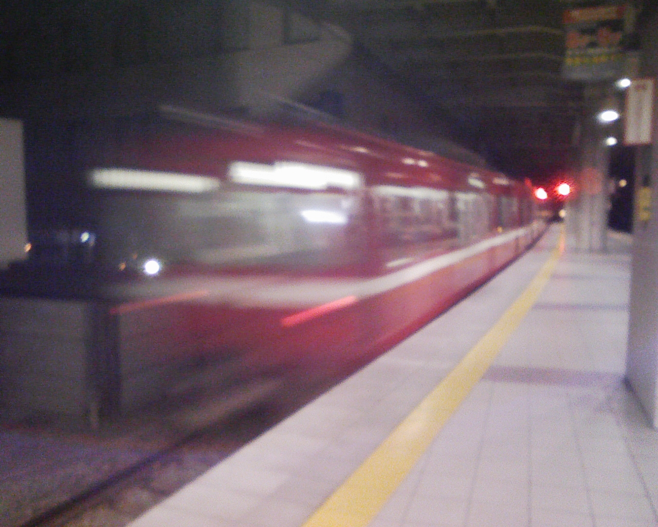 blurry image of red train moving at the station