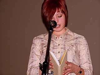 a girl with red hair is holding a guitar