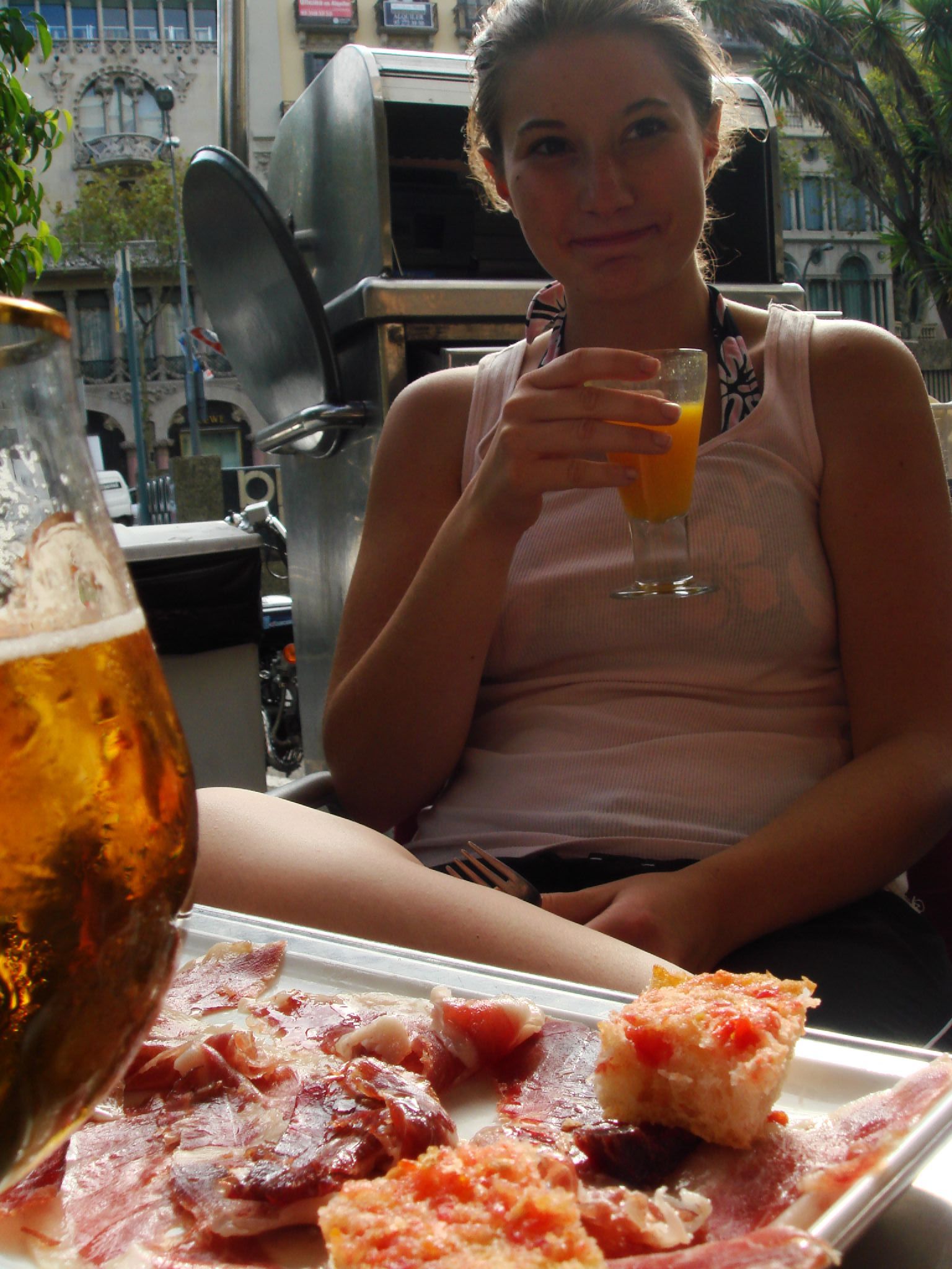 a woman is sitting with her arm out and drinking beer