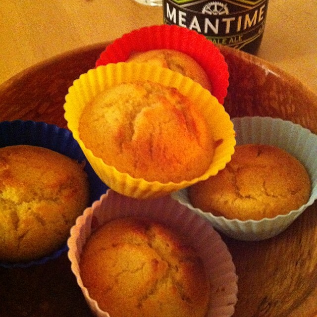 muffins sitting on a plate with cups of coffee next to them