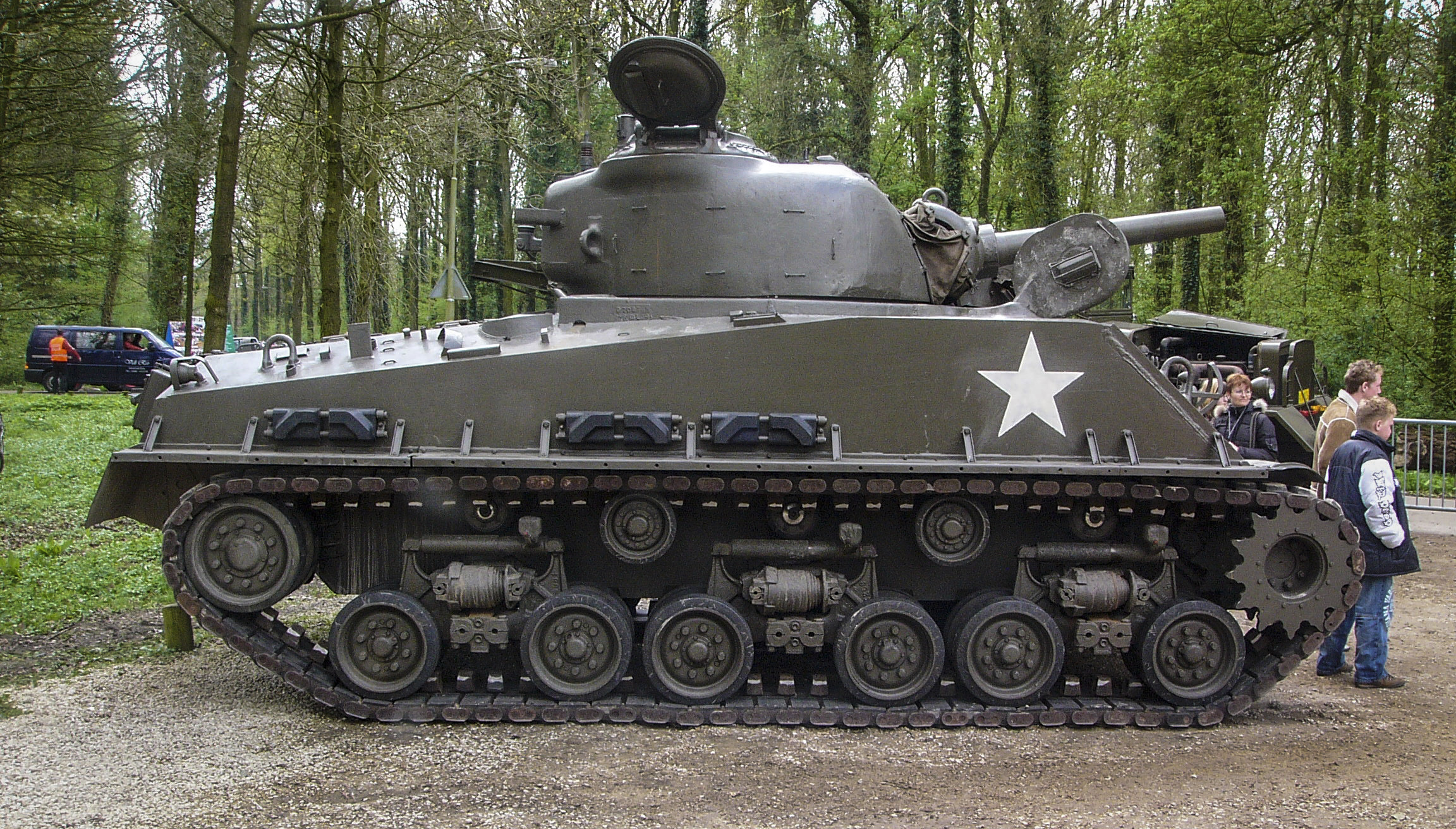 a large tank sitting in the middle of a forest
