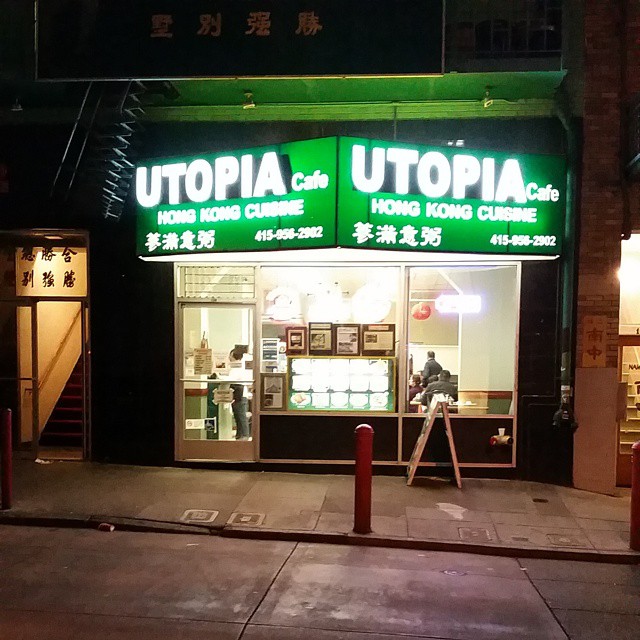 the entrance to utopia cooking school is lit at night