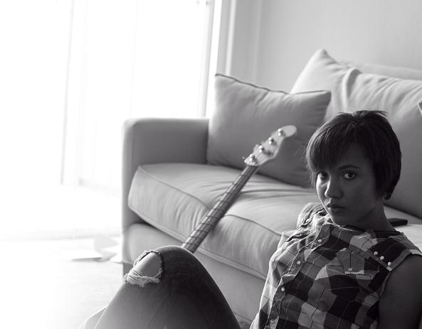 a young lady is posing for a po while holding a guitar