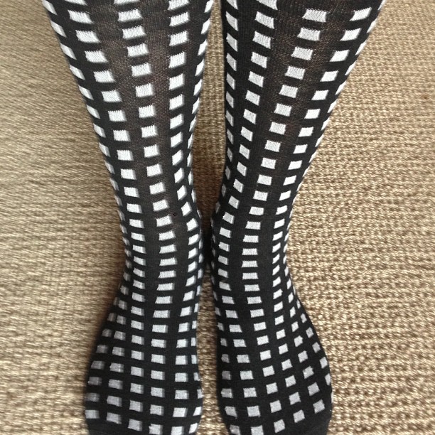 someone wearing socks and heels that are black and white with a checkered design