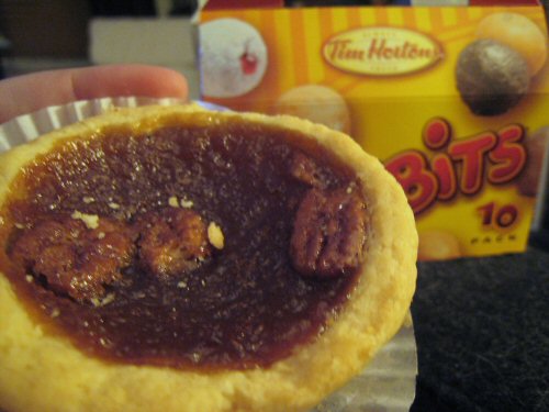 a person holding a chocolate filled pastie in front of a box