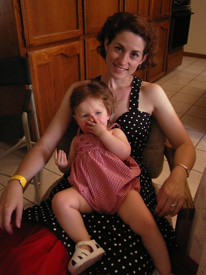 woman holding child on couch with wooden cabinet