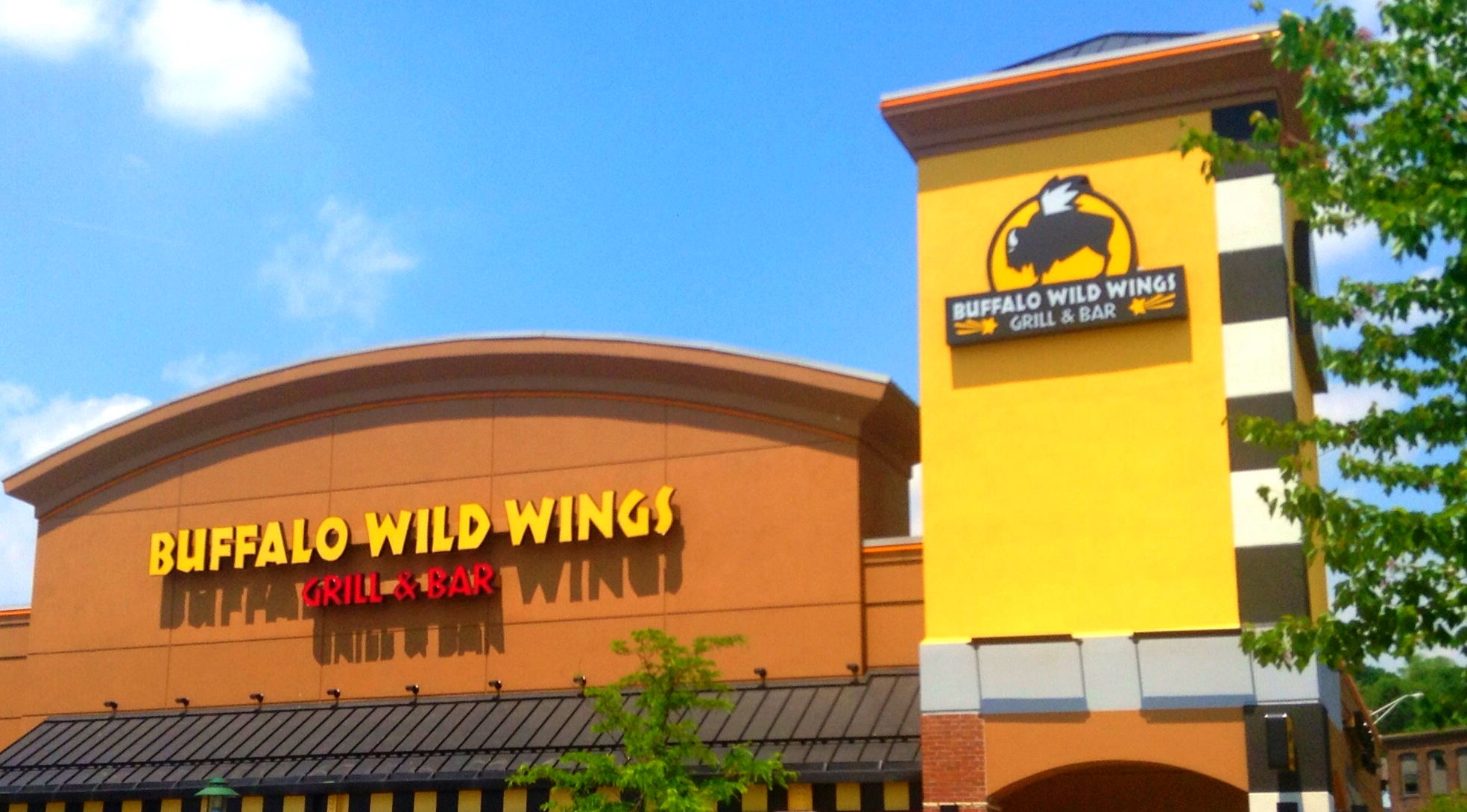 a store with an open front and yellow building on the corner