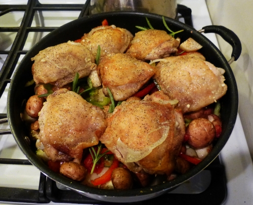 cooked chicken with vegetable stir fry in black pan
