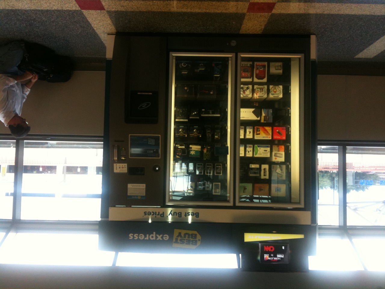 a man sitting on the ground beside an open vending machine