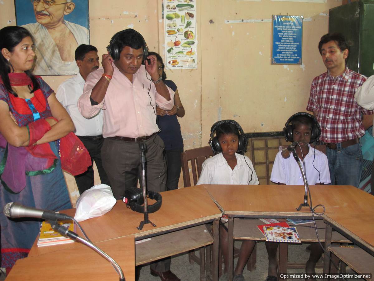 a man surrounded by several young children sitting around a table