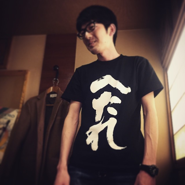 young man standing wearing a shirt that reads yin