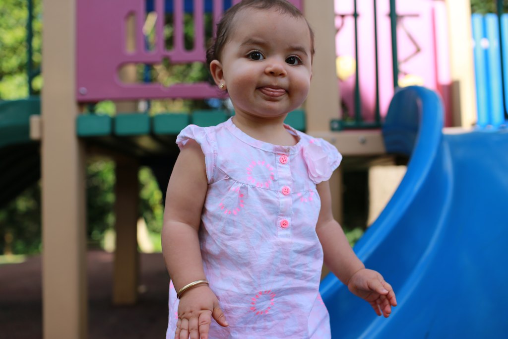  standing in front of colorful playground slide and swings