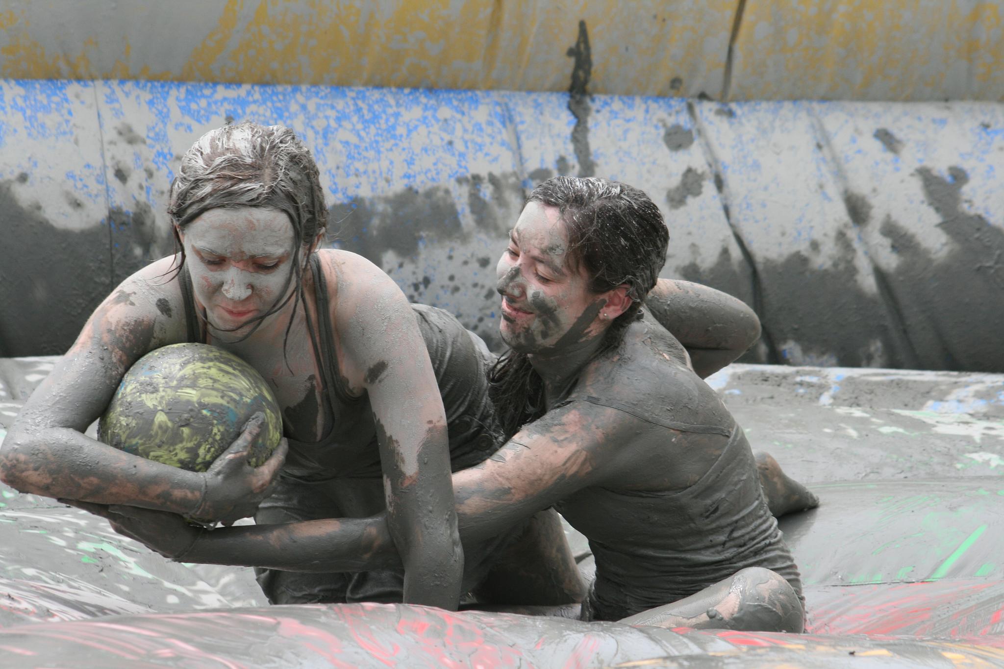 some people and a ball in the mud
