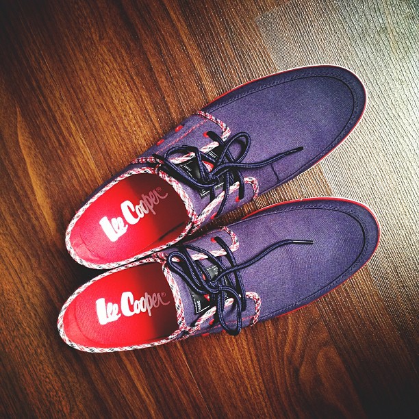a pair of purple tennis shoes with red and white laces