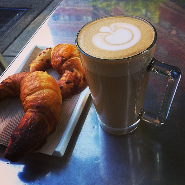 a cup and some croissants are on a tray