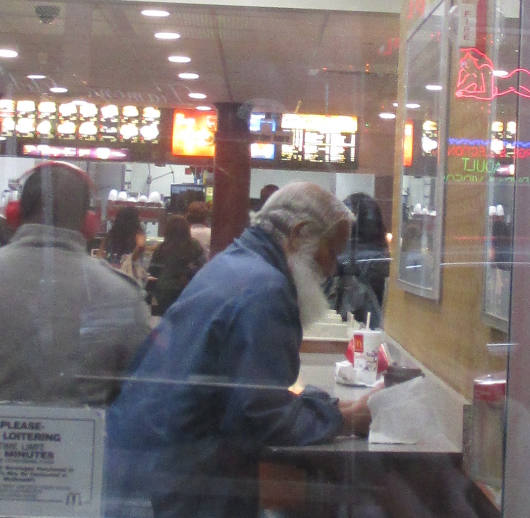 a man in blue sweatshirt standing at desk in store