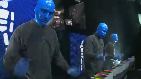 some people with blue hair standing around a dance