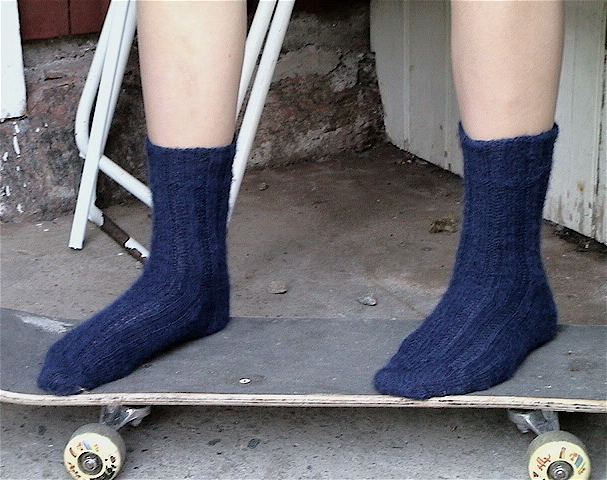 feet wearing socks while riding on top of a skateboard