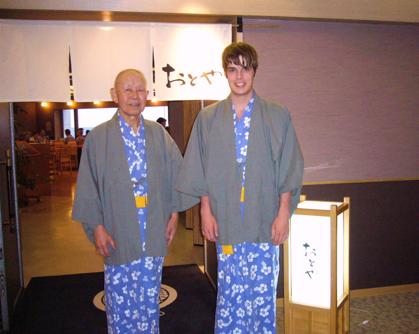 an old man standing next to a young man dressed in pajamas