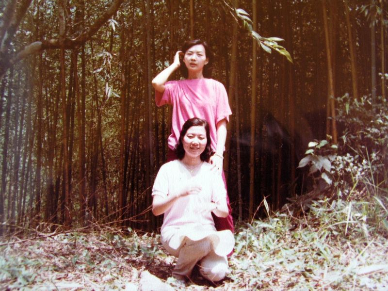 two people in front of a tree in a forest