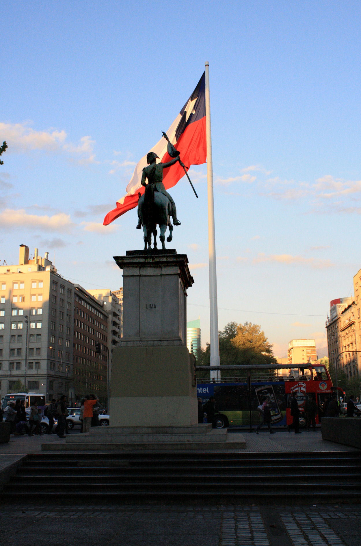 the flag and the statue stand tall in a plaza