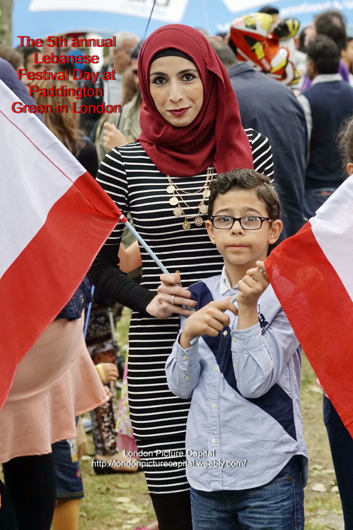 a woman and boy pose with flags outside